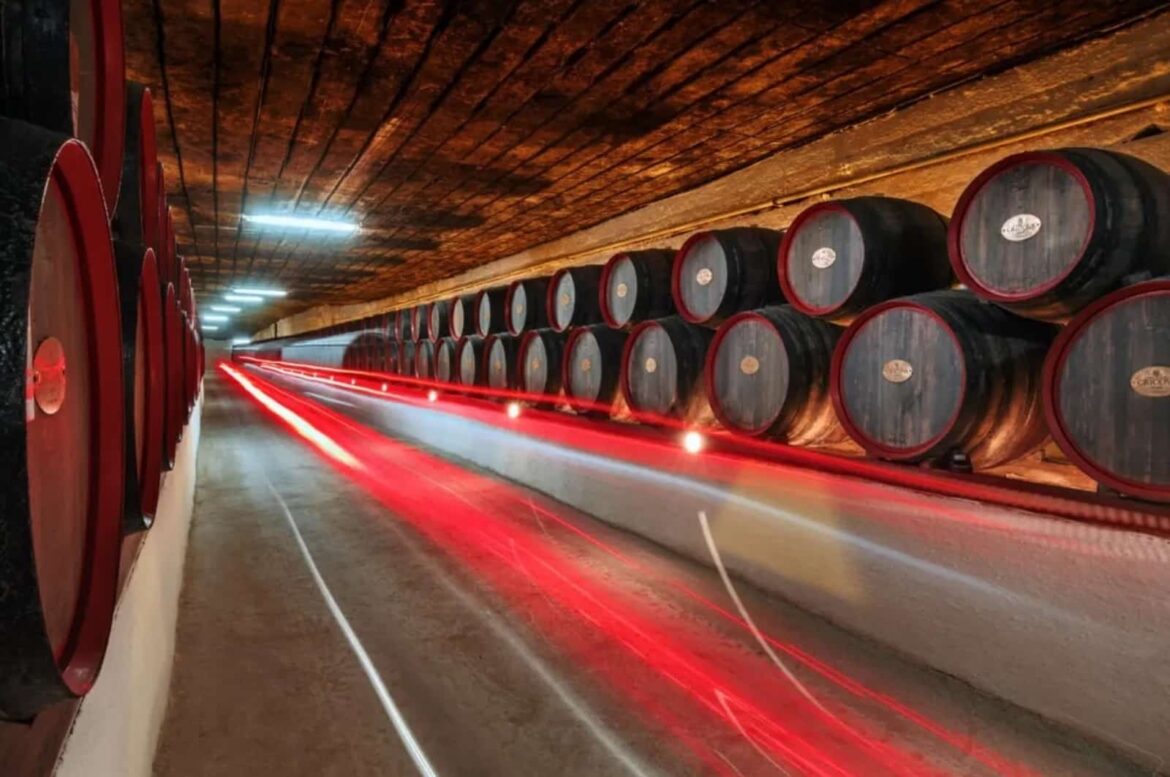 Long-exposure photo showing red light trails from a moving vehicle in a historic Cricova wine cellar tunnel, a unique experience during a wine tour in Moldova.